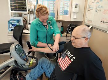 Kinesiologist takes patient's blood pressure